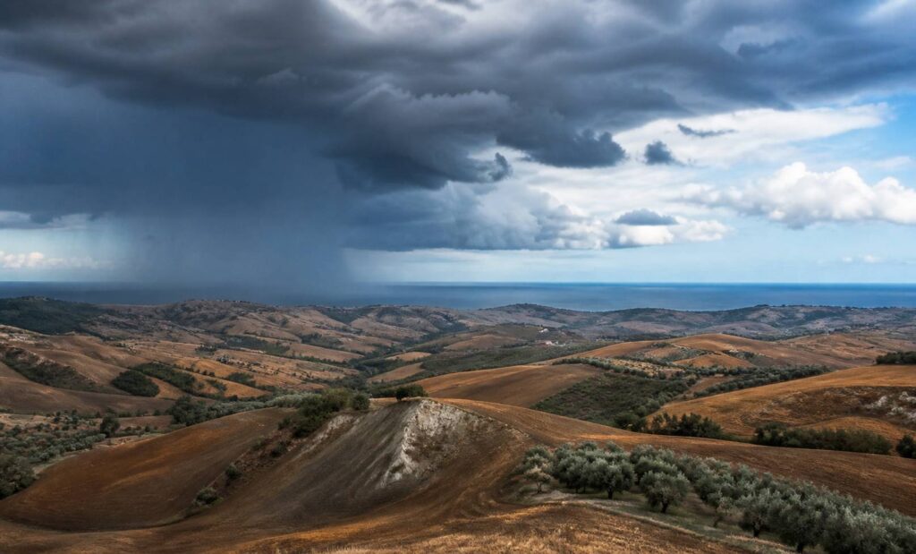 Collines des Marches sous des nuages d'orage avec lignes de pluie au loin