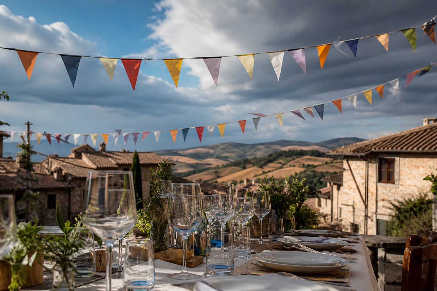 Table de banquet en plein air avec guirlandes et place de village en fond