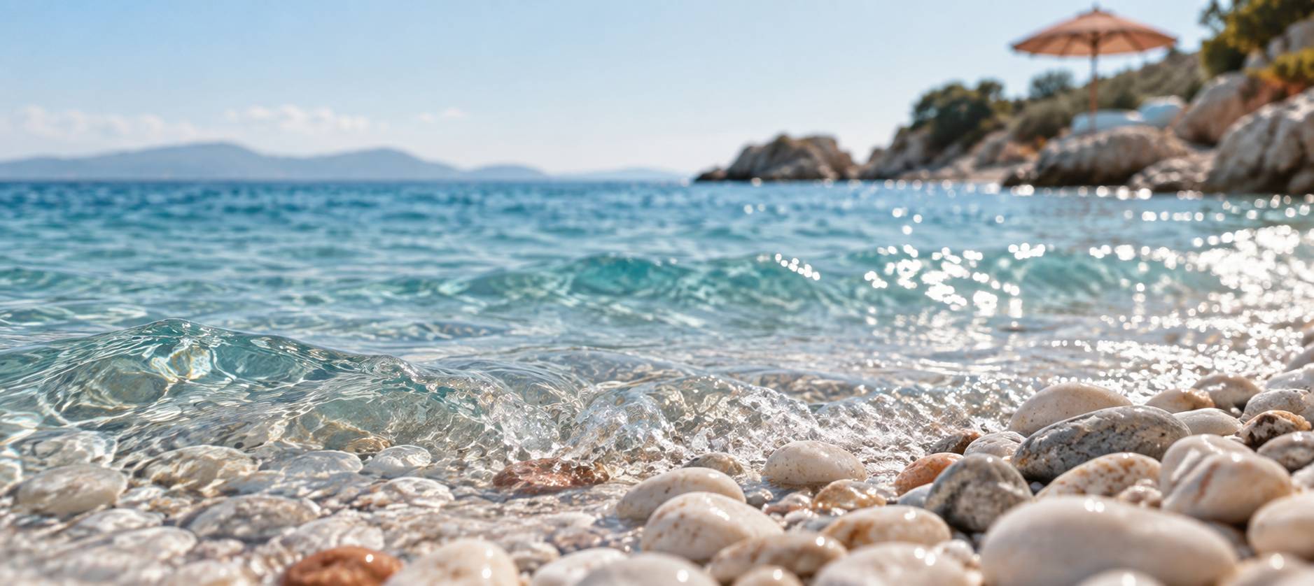 Gros plan sur l'eau turquoise de l'Adriatique venant sur des galets